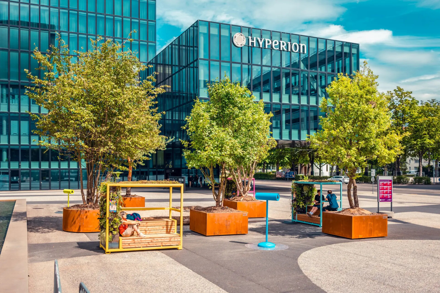 Aktuelle Projektbeispiele von Mobile Green, Einsatz in Basel Stadt (BS) mit über 170'000 Einwohnern: Seit dem 18.07.2023 stehen auf dem Messeplatz fünf Pflanztröge mit Grossbäumen und spenden Schatten. Die mobilen Trogsysteme sind mit Wassertanks von bis zu 410 Liter ausgestattet. © Copyright Bauer Baumschulen| Digitale Medienmappe «Mobile Begrünungen schützen Städte vor Überhitzung – Schweizer Innovation zum Patent angemeldet», Bauer Baumschulen