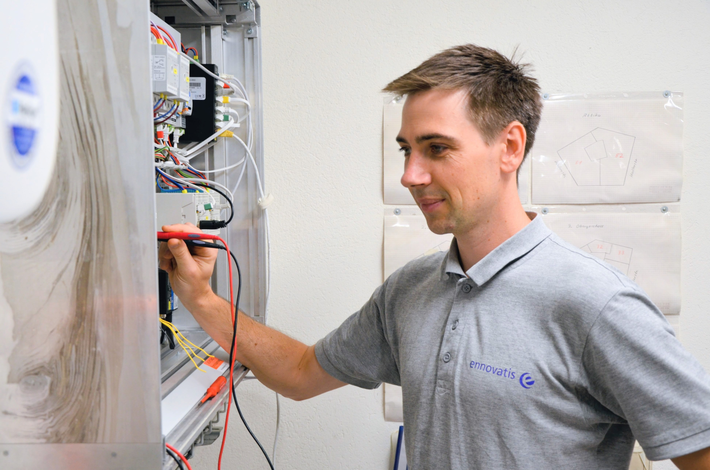 Präzise Arbeit am Schaltschrank: Ein ennovatis-Techniker überprüft die Steuerungstechnik für den reibungslosen Betrieb. © Copyright | Digitale Medienmappe «In 25 Jahren vom Nischenthema zur Schlüsseltechnologie der Energiewende», ennovatis Schweiz AG